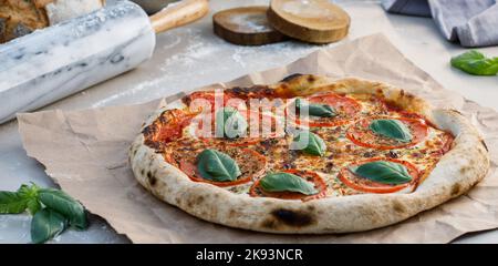 Margherita Pizza auf dem Tisch mit Artikeln Stockfoto