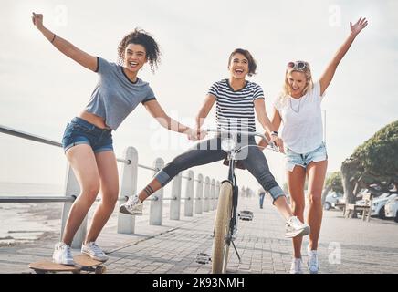 Am liebsten machen wir Viel Spaß. drei Freunde, die Spaß an der Promenade haben. Stockfoto