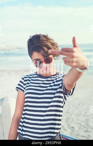 Heiß und belästigt. Eine junge Frau zeigt Mittelfinger. Stockfoto