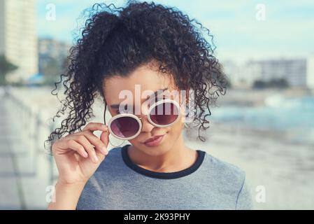 Eine junge Frau, die den Tag auf der Strandpromenade verbringt. Stockfoto