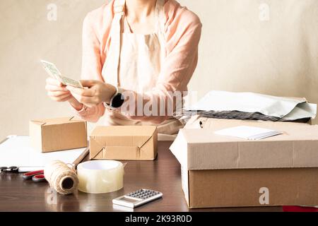 Frauen Online-Shop, Kleinunternehmer, Unternehmer, Mailbox bereitet ein Paket auf dem Tisch für den Versand. Dropshipping Lieferkonzept in e-comm Stockfoto