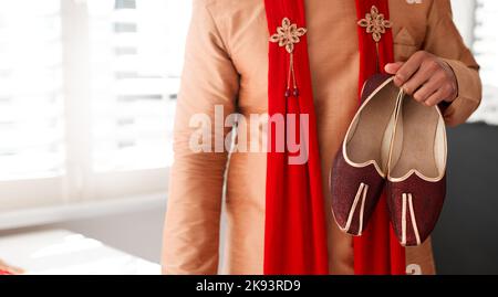 Ich mache meinen ersten Schritt in die Ehe mit diesen. Ein unkenntlich Mann, der Schuhe anzieht, um sich auf seine Hochzeit vorzubereiten. Stockfoto