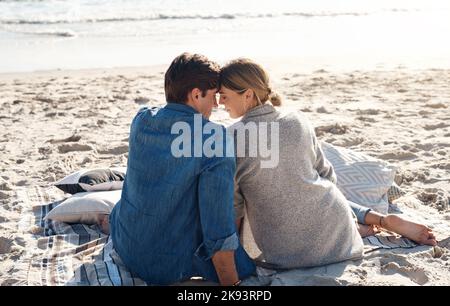 Wir sind Liebhaber des Meeres. Rückansicht eines Paares mittleren Alters, das am Strand sitzt. Stockfoto