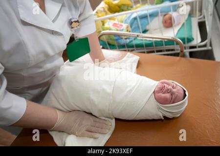 Neonatologie. Ein Neugeborenes in einem speziellen Inkubator. Medizinisches Personal, das sich im Krankenhaus um ein Neugeborenes kümmert. Stockfoto