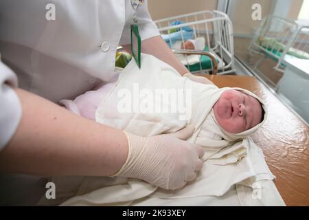 Neonatologie. Ein Neugeborenes in einem speziellen Inkubator. Medizinisches Personal, das sich im Krankenhaus um ein Neugeborenes kümmert. Stockfoto