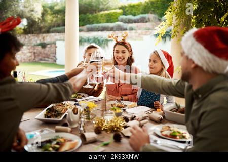 Wir werden die Familie nicht für alles tauschen, eine Familie, die am Weihnachtstag anstoast. Stockfoto