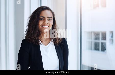 Ich werde ganz nach oben aufsteigen. Porträt einer jungen Geschäftsfrau, die in einem Büro steht. Stockfoto