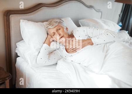 Als letztes haben Sie Ihr Herz überprüft. Eine ältere Frau, die Brustschmerzen im Bett in einem Pflegeheim hat. Stockfoto