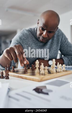 Genau wie Schach, können Sie nicht erfolgreich sein, ohne einen Schritt zu machen. Ein reifer Geschäftsmann spielen Schach in seinem Büro. Stockfoto