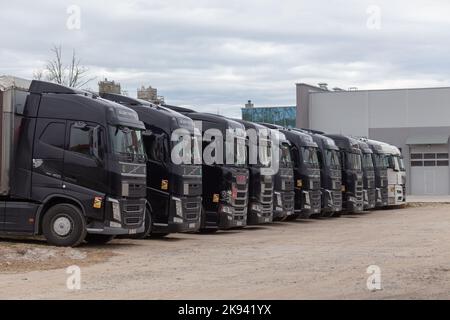 Grodno, Weißrussland - 18. April 2022: Reihe verschiedener Firmen-Lkw, die auf einem LKW-Parkplatz über Nacht wegen der Sanktionen geparkt wurden, die Weißrussland nicht zulassen Stockfoto