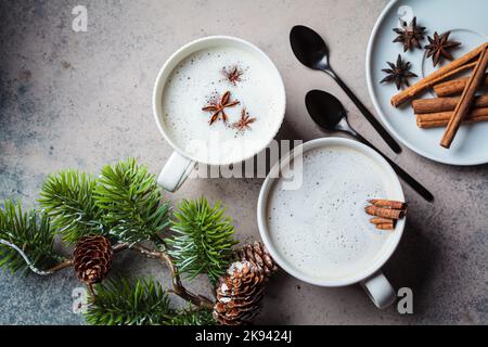 Hausgemachter Chai Latte mit Zimt und Sternanis in einer weißen Tasse, dunkler Hintergrund, Draufsicht. Weihnachtliche Hintergrund und Wintergetränk. Stockfoto