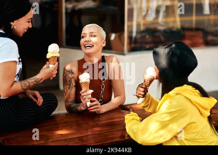Ein Eisdiele ist genau das, was wir brauchten. Drei Freunde genießen Eisdielen, während sie in der Stadt sind. Stockfoto