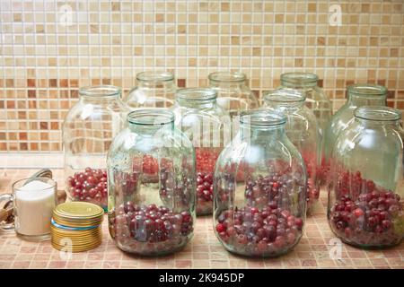 Zubereitung in drei-Liter-Gläsern Kirschkompott. Herstellungsprozess. Lifestyle. Stockfoto