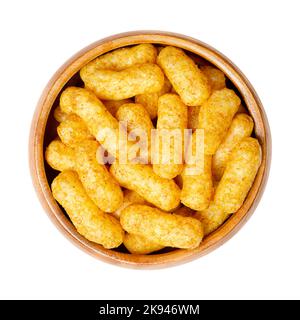 Erdnuss dreht sich in einer Holzschale. Auch bekannt als Bamba, Erdnusspuffs oder Snips, ist ein gepuffter Mais-Snack mit Erdnussgeschmack. Stockfoto