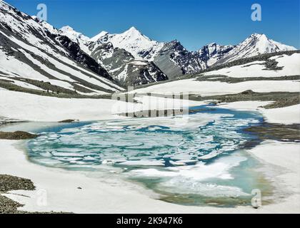 Der türkisfarbene gefrorene See auf dem Höhenpass von Shingo La in der Great Himalayan Range auf dem Trek von Lahaul nach Zanskar in Nordindien Stockfoto