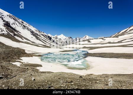 Der türkisfarbene gefrorene See auf dem Höhenpass von Shingo La in der Great Himalayan Range auf dem Trek von Lahaul nach Zanskar in Nordindien Stockfoto