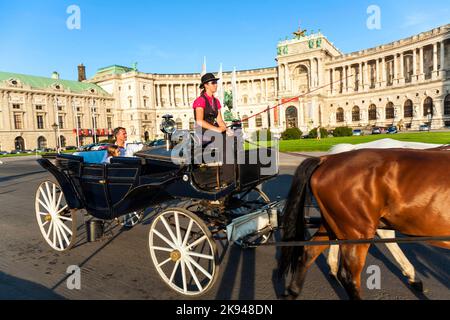 Wien, Österreich - 21. Juli 2009: Die Menschen reiten im Fiaker und passieren die Hofburg in Wien. Der Fiaker wurde zuerst im 18. Jahrhundert in der gebaut Stockfoto