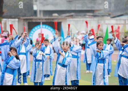 LIUZHOU, CHINA - 26. OKTOBER 2022 - Studenten in Hanfu zeigen Fächertanz während eines Track and Field-Treffen im Rong 'an County Experimental Primary Sch Stockfoto