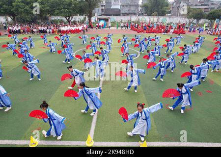 LIUZHOU, CHINA - 26. OKTOBER 2022 - Studenten in Hanfu zeigen Fächertanz während eines Track and Field-Treffen im Rong 'an County Experimental Primary Sch Stockfoto