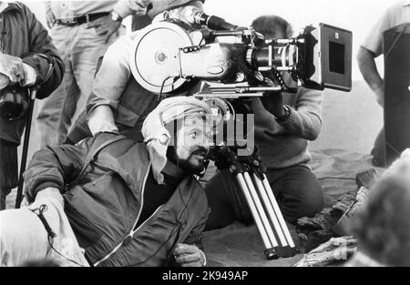 Regisseur JOHN MILIUS am Drehort offen mit Camera / Movie Crew während Dreharbeiten in Spanien für ARNOLD SCHWARZENEGGER in CONAN DER BARBAR 1982 Regisseur JOHN MILIUS basierend auf der Figur von Robert E. Howard geschrieben von John Milius und Oliver Stone Musik Basil Poledouris Dino De Laurentiis Unternehmen / Pressman Film / Estudios Churubusco Azteca S.A. / A-Team / Universal Pictures Stockfoto