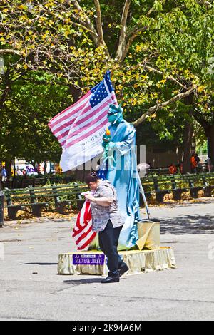 New York, USA - 9. Juli 2010: Straßenperformance im Battery Park in New York City. Mann, der als Freiheitsstatue mit Pantomime gekleidet ist, bittet um Spende. Stockfoto