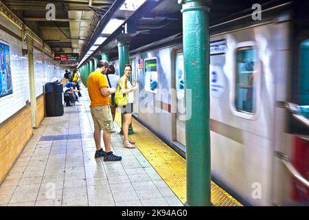 NEW YORK CITY - 11. Juli: Am 11. Juli 2010 in New York City warten Menschen auf die U-Bahn in der Straße 135. Die erste U-Bahn-Linie wurde am 27. Oktober 1 eröffnet Stockfoto
