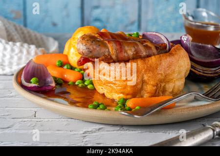 Kröte im Loch mit Yorkshire Pudding, Würstchen und Gemüse Stockfoto