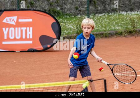 Kinder, die Tennis spielen und Tennisunterricht nehmen Stockfoto