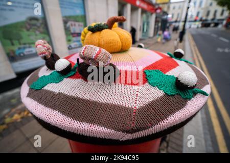 London, Großbritannien. 26 Oktober 2022 . Ein Briefkasten im Stadtzentrum von Wimbledon im Südwesten Londons mit einem gestrickten Topper mit Halloween-Motiv und gehäkeltem Kürbis. Kredit: amer ghazzal/Alamy Live Nachrichten Stockfoto