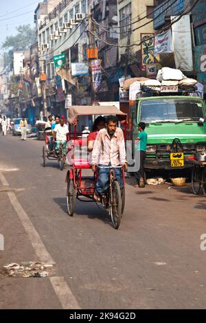 DELHI, INDIEN - NOV 9: Rikscha-Fahrer transportiert Passagiere am frühen Morgen des 08,2011. November in Delhi, Indien. Zyklus-Rikschas wurden in Del eingeführt Stockfoto