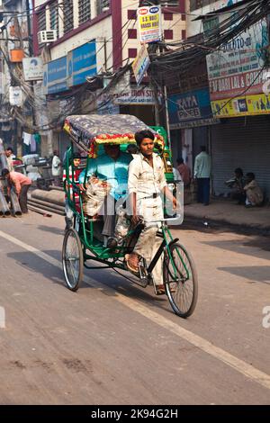 DELHI, INDIEN - NOV 9: Rikscha-Fahrer transportiert Passagiere am frühen Morgen des 08,2011. November in Delhi, Indien. Zyklus-Rikschas wurden in Del eingeführt Stockfoto