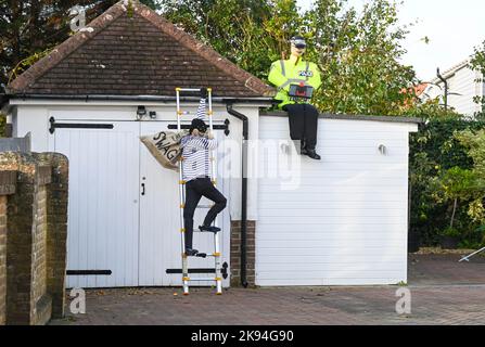 Worthing UK 26. October 2022 - Im Rahmen des jährlichen Vogelscheuchen-Festivals sind Vor einem Haus im Dorf Ferring bei Worthing ein Einbrecher und ein Polizeibeamter aufgetaucht. Über 70 Vogelscheuchen werden voraussichtlich über die Woche im ganzen Dorf erscheinen : Credit Simon Dack / Alamy Live News Stockfoto