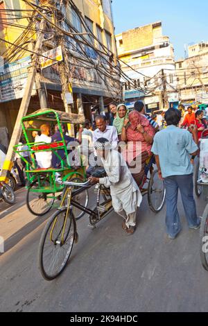 DELHI, INDIEN - NOV 8: Rikscha-Fahrer transportiert Passagiere am frühen Morgen des 08,2011. November in Delhi, Indien. In Delhi wurden Fahrradrickshaws eingeführt Stockfoto