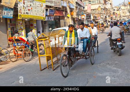 DELHI, INDIEN - NOV 8: Rikscha-Fahrer transportiert Passagiere am frühen Morgen des 08,2011. November in Delhi, Indien. In Delhi wurden Fahrradrickshaws eingeführt Stockfoto