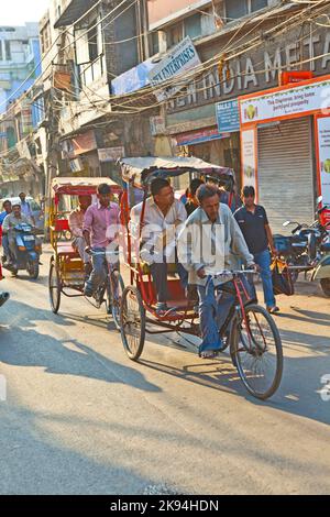 DELHI, INDIEN - NOV 8: Rikscha-Fahrer transportiert Passagiere am frühen Morgen des 08,2011. November in Delhi, Indien. In Delhi wurden Fahrradrickshaws eingeführt Stockfoto