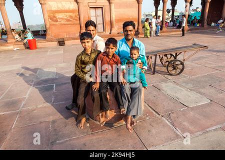 DELHI, INDIEN - NOV 8: Vater als Verehrer mit Familie ruht am 8,2011. November auf dem Hof der Jama Masjid Moschee in Delhi. Jama Masjid ist das Prinzip Stockfoto