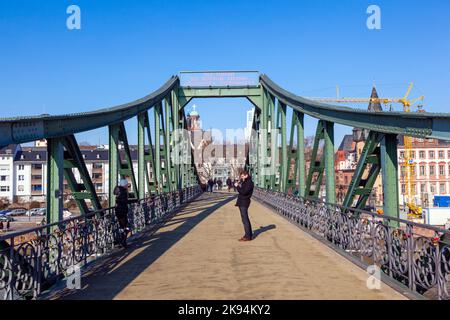 FRANKFURT, DEUTSCHLAND - FEBRUAR 2: Am 2. Februar 2012 in Frankfurt, Deutschland, überqueren die Menschen gerne den Main am Eiserner Steg. Die Brücke aus dem Jahr 1 Stockfoto