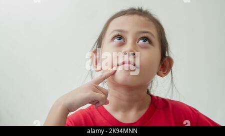 Little Asian Girl sieht aus wie etwas zu denken Stockfoto