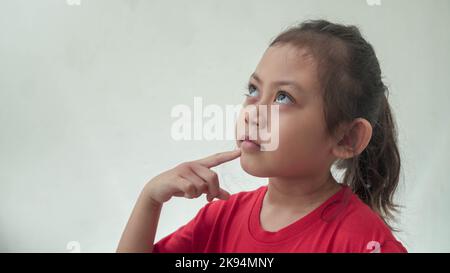 Little Asian Girl sieht aus wie etwas zu denken Stockfoto