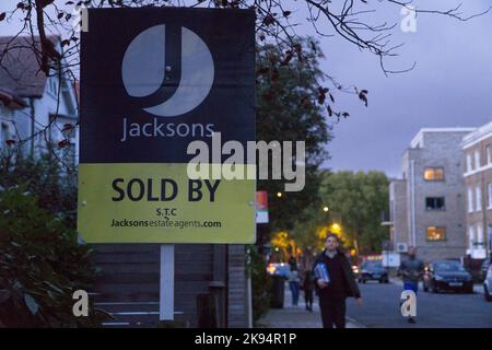 London, Großbritannien, 24. Oktober 2022: Das "for Sale"-Schild eines Immobilienmaklers vor einem Haus in Clapham in der Abenddämmerung. Hohe Zinssätze und die Lebenshaltungskosten dürften einen Abschwung auf dem Wohnungsmarkt verursachen. Anna Watson/Alamy Live News Stockfoto