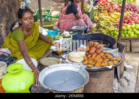 JAIPUR, INDIEN - 25. AUGUST: Indische Frauen verkaufen Brot und frisch gekochte Kuchen am 25. August 2012 in Jaipur, Indien. In Indien verkaufen arme Frauen häufig Gemüse Stockfoto