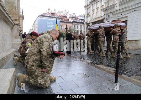 Lviv, Ukraine. 25. Oktober 2022. Ukrainische Soldaten knien, während ukrainische Soldaten den Sarg während der Beerdigungszeremonie des Oberstleutnants Dmytro Kutschynskyi tragen, der während der russischen Invasion in die Ukraine von russischen Terroristen getötet wurde. Russland marschierte am 24. Februar 2022 in die Ukraine ein und löste damit den größten militärischen Angriff in Europa seit dem Zweiten Weltkrieg aus Kredit: SOPA Images Limited/Alamy Live Nachrichten Stockfoto