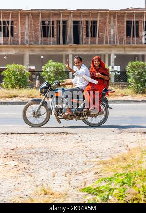 RAJASTHAN, INDIEN - 18. OKTOBER: Mutter, Vater und kleines Kind reiten am 18. Oktober 2012 in Rajasthan, Indien, auf einem Roller durch eine verkehrsreiche Straße auf der Autobahn. U Stockfoto