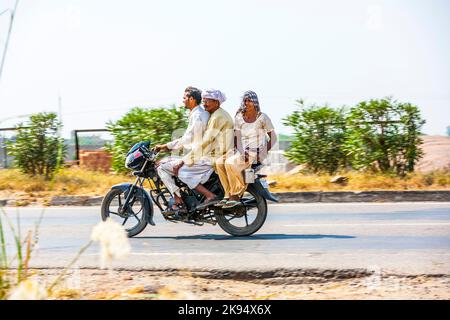 RAJASTHAN - INDIEN - OKTOBER 18: Mutter, Vater und kleines Kind Reiten auf Roller durch verkehrsreiche Autobahn Straße am 28. Oktober 2012 in Rajasthan, Indien. Stockfoto