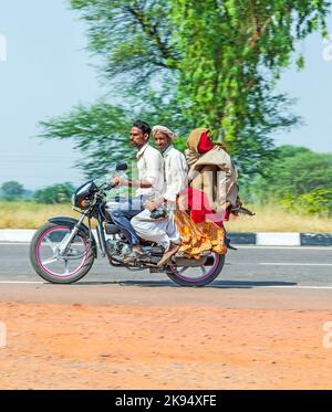 RAJASTHAN - INDIEN - OKTOBER 18: Mutter, Vater und kleines Kind Reiten auf Roller durch verkehrsreiche Autobahn Straße am 28. Oktober 2012 in Rajasthan, Indien. Stockfoto