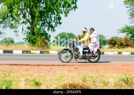 RAJASTHAN - INDIEN - OKTOBER 18: Mutter, Vater und kleines Kind Reiten auf Roller durch verkehrsreiche Autobahn Straße am 28. Oktober 2012 in Rajasthan, Indien. Stockfoto