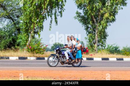 RAJASTHAN - INDIEN - OKTOBER 18: Mutter, Vater und kleines Kind fahren Roller durch geschäftige Autobahn Straße am 18. Oktober 2012 in Rajasthan, Indien. Bis zu Stockfoto