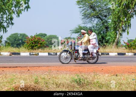 RAJASTHAN - INDIEN - OKTOBER 18: Mutter, Vater und kleines Kind Reiten auf Roller durch verkehrsreiche Autobahn Straße am 28. Oktober 2012 in Rajasthan, Indien. Stockfoto