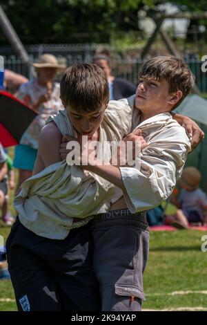 Zwei junge Brüder im Teenageralter treten beim Grand Cornish Wrestling Tournament auf dem malerischen Dorfgrün von St. Mawgan in Pydar in Cornwall in an Stockfoto