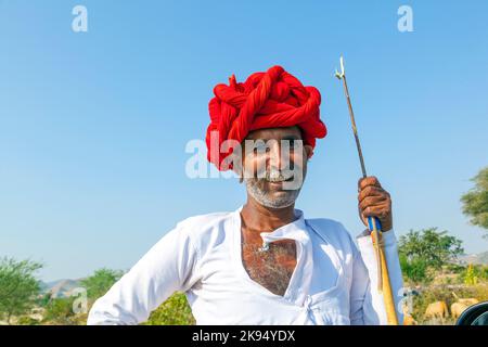 PUSHKAR, INDIEN - 22. OKTOBER: Ein Stammesmann aus Rajasthani trägt traditionellen bunten Turban und liebt es, auf der jährlichen Pushkar Cattle Fair auf Octob zu posieren Stockfoto